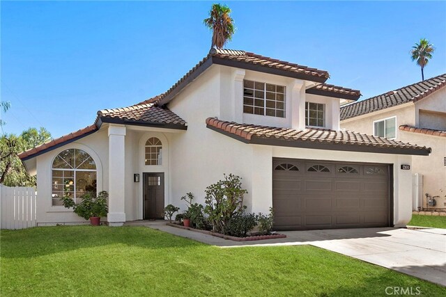 mediterranean / spanish home featuring a front lawn and a garage