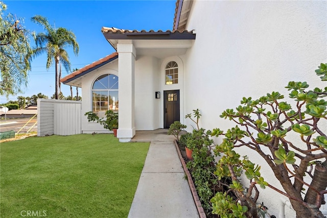 property entrance featuring a lawn