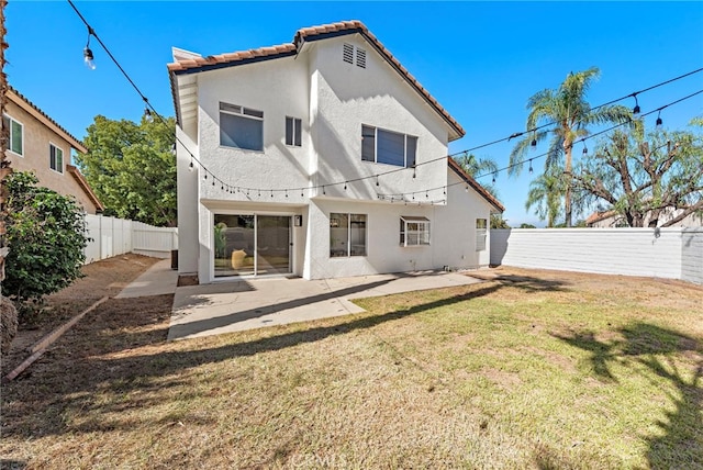 back of house with a patio area and a yard