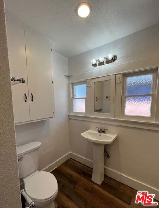 bathroom with toilet and hardwood / wood-style floors