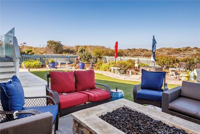 view of patio with an outdoor living space with a fire pit