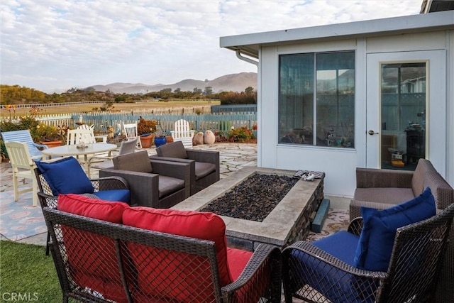 view of patio featuring a mountain view and an outdoor living space with a fire pit