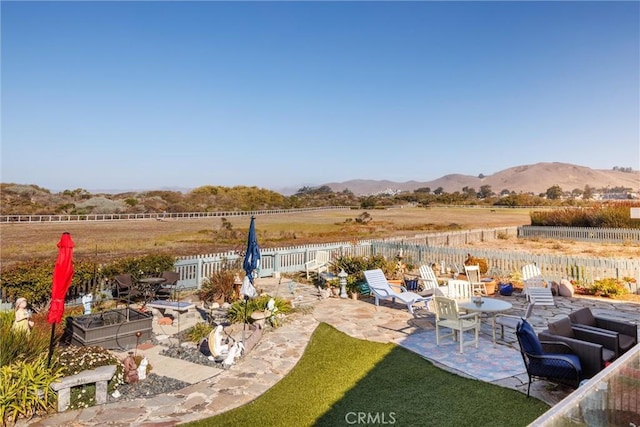 view of yard featuring a mountain view, a rural view, and a patio area