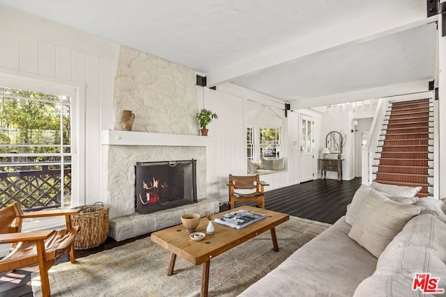 living room with a fireplace, hardwood / wood-style floors, and beam ceiling