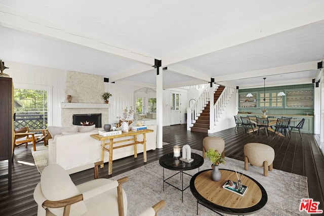 living room with hardwood / wood-style flooring, beam ceiling, and a fireplace