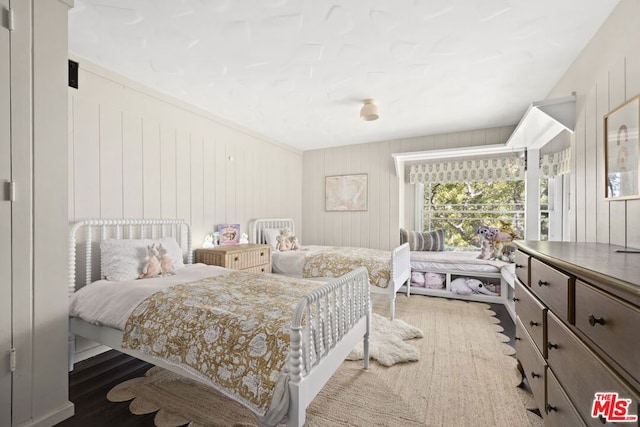 bedroom featuring hardwood / wood-style floors and wooden walls