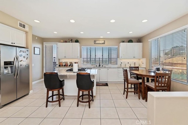 kitchen featuring white cabinets, a wealth of natural light, a center island, and appliances with stainless steel finishes