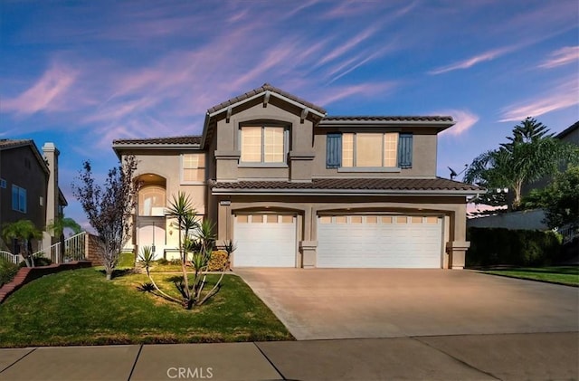 mediterranean / spanish house with a yard and a garage