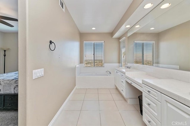 bathroom with tile patterned floors, vanity, ceiling fan, and a relaxing tiled tub