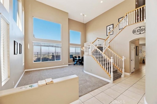 staircase with carpet floors and a high ceiling