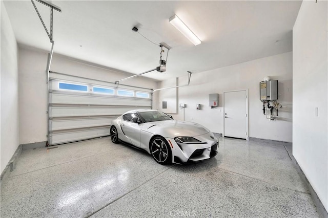 garage featuring electric panel, tankless water heater, and a garage door opener