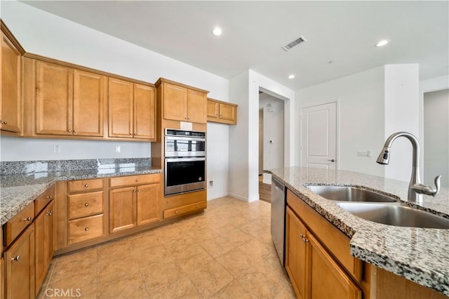 kitchen with light stone counters, sink, and stainless steel appliances