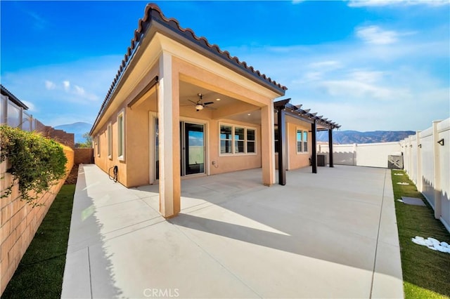 exterior space with a mountain view, ceiling fan, and a patio area