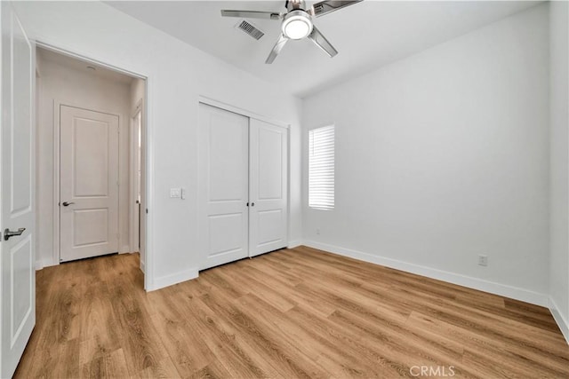 unfurnished bedroom with a closet, light hardwood / wood-style flooring, and ceiling fan