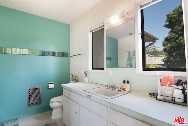 bathroom with vanity, a baseboard radiator, toilet, and heating unit