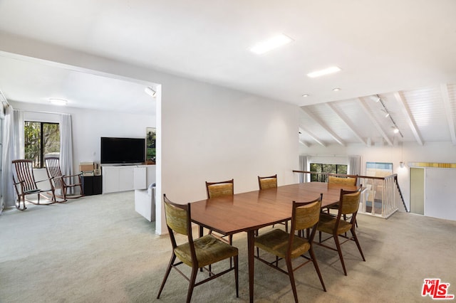 dining area featuring vaulted ceiling with beams and light carpet