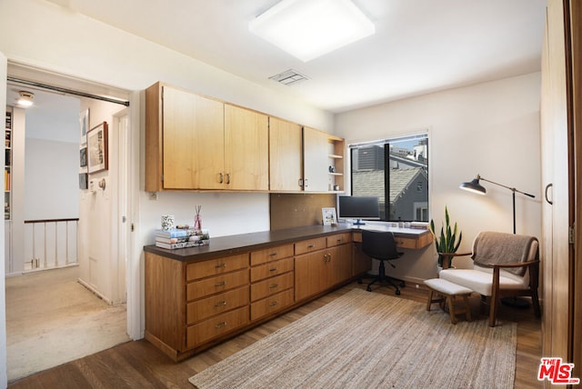 kitchen featuring light hardwood / wood-style floors and built in desk