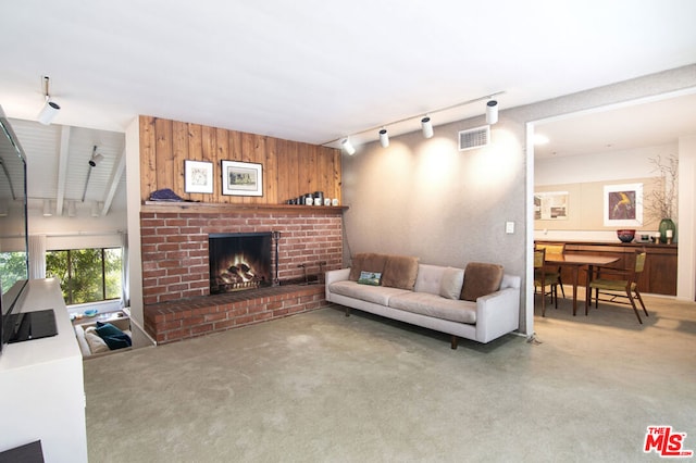 living room featuring rail lighting and a brick fireplace