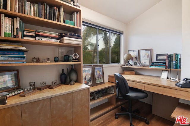 office space with hardwood / wood-style flooring, built in desk, and vaulted ceiling