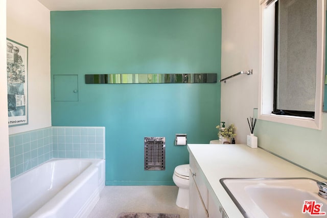 bathroom featuring a bathtub, vanity, and toilet