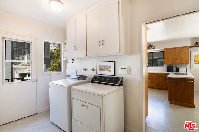 washroom featuring separate washer and dryer, sink, and cabinets