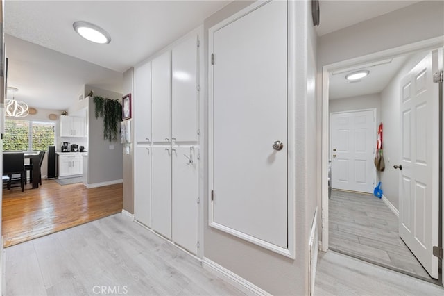 corridor with light hardwood / wood-style flooring