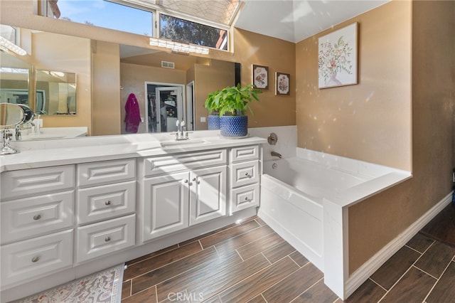 bathroom with a washtub and vanity