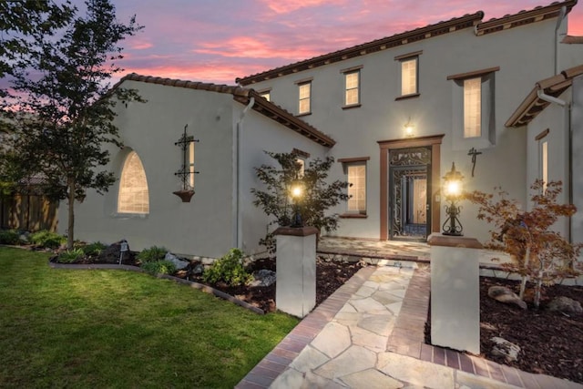 view of front of property with a lawn and a patio