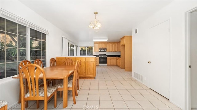 tiled dining room with a healthy amount of sunlight and an inviting chandelier