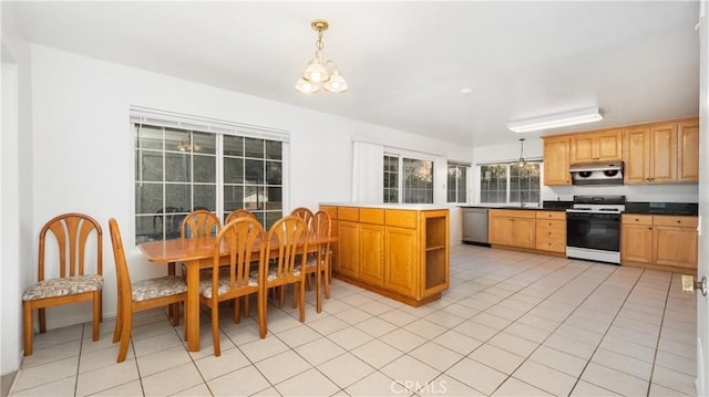 kitchen with decorative light fixtures, stainless steel appliances, an inviting chandelier, and light tile patterned flooring