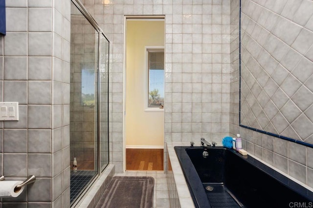 bathroom featuring tile patterned flooring and shower with separate bathtub