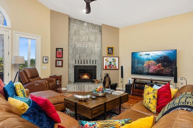 living room featuring a tiled fireplace and hardwood / wood-style floors