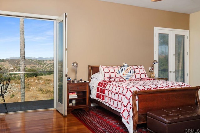 bedroom featuring a mountain view, french doors, ceiling fan, and wood-type flooring