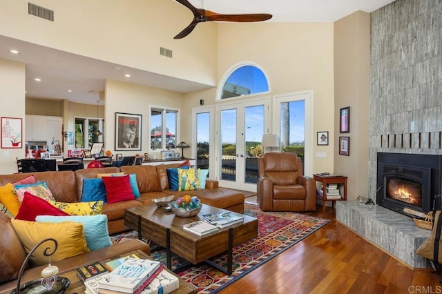 living room with a high ceiling, french doors, hardwood / wood-style flooring, and a wealth of natural light