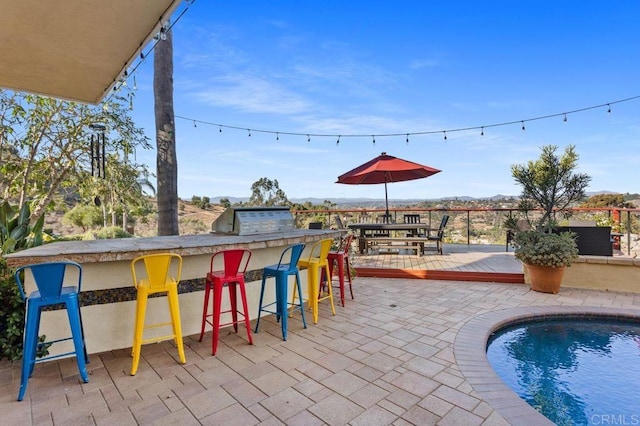 view of patio featuring a swimming pool side deck and an outdoor bar