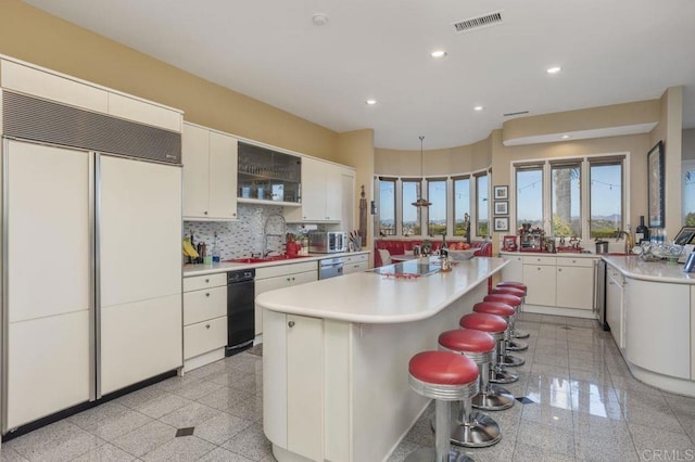 kitchen with white cabinetry, a center island, paneled built in fridge, and sink