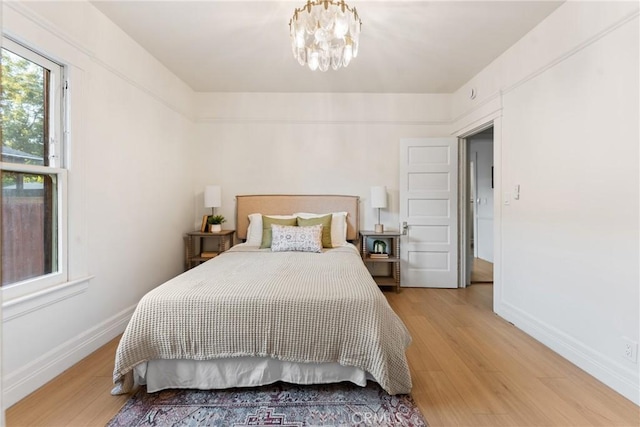 bedroom with wood-type flooring and a notable chandelier