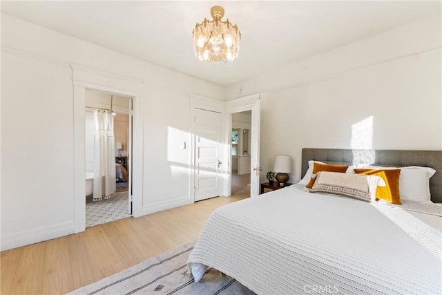 bedroom with hardwood / wood-style floors and an inviting chandelier