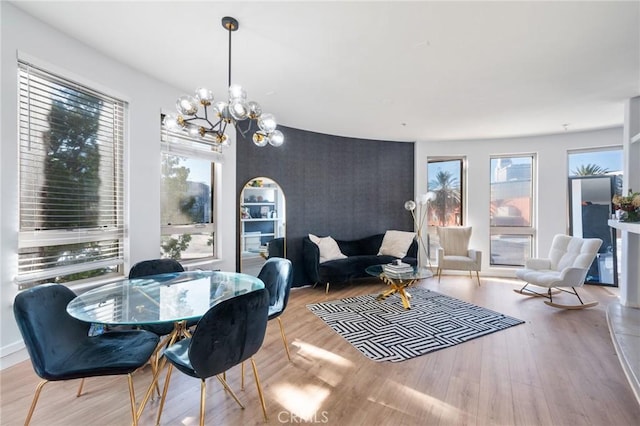 dining area with light hardwood / wood-style floors and an inviting chandelier