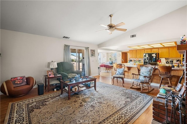 living room featuring ceiling fan, light hardwood / wood-style flooring, and lofted ceiling