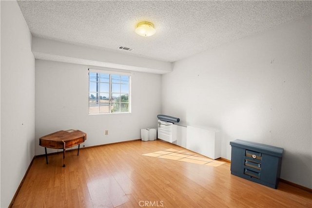 spare room with wood-type flooring and a textured ceiling