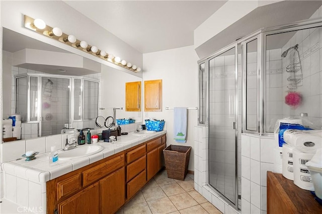 bathroom featuring tile patterned flooring, vanity, and a shower with door