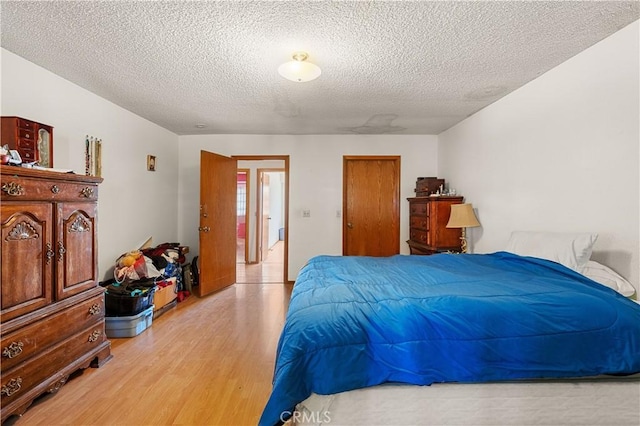 bedroom featuring a textured ceiling and light hardwood / wood-style flooring