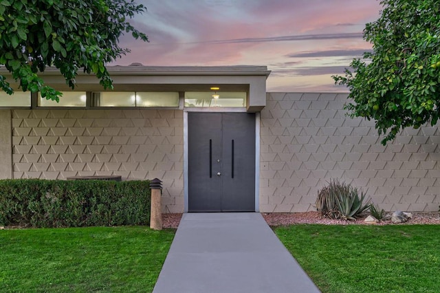 exterior entry at dusk with a lawn