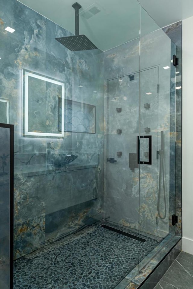 bathroom with a shower with door