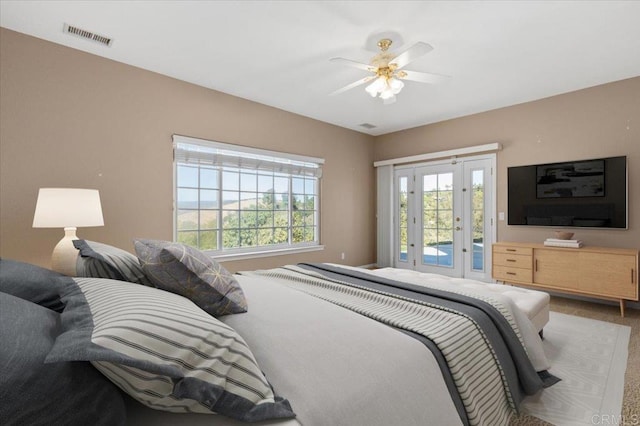 carpeted bedroom with access to outside, ceiling fan, and multiple windows