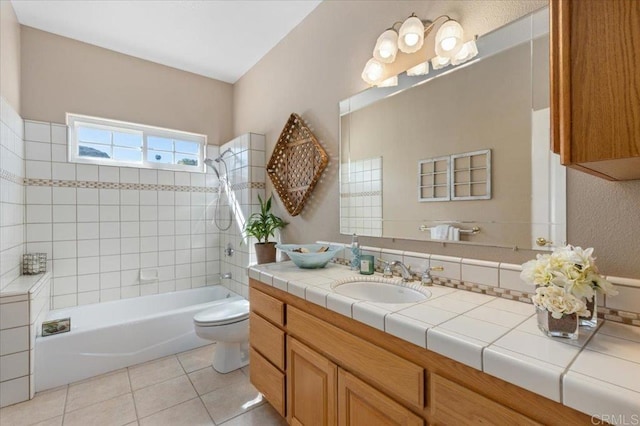 full bathroom with toilet, tiled shower / bath combo, tile patterned floors, and vanity