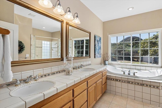 bathroom with tile patterned flooring, shower with separate bathtub, a wealth of natural light, and vanity