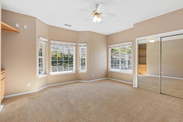 unfurnished bedroom with light colored carpet, ceiling fan, and a closet