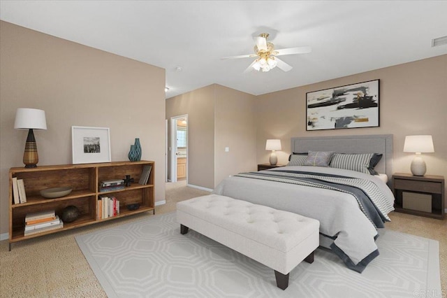 bedroom featuring ensuite bath, ceiling fan, and light carpet